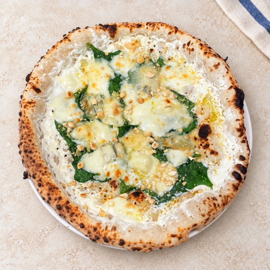 Pizza Spinaci z liśćmi szpinaku, roztopionym serem i posiekanymi orzechami